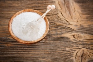 Xylitol in wooden bowl with candy sugar on sticks