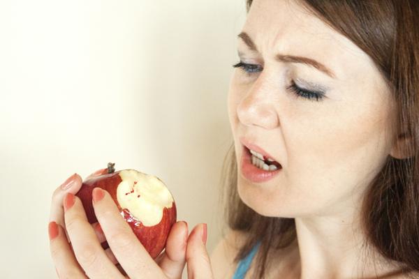 Girl with bleeding gums eating an apple