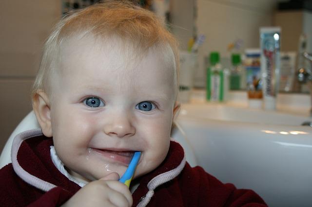 Baby learning to brush her teeth