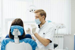 Dentist check patient cavity using instruments at clinic