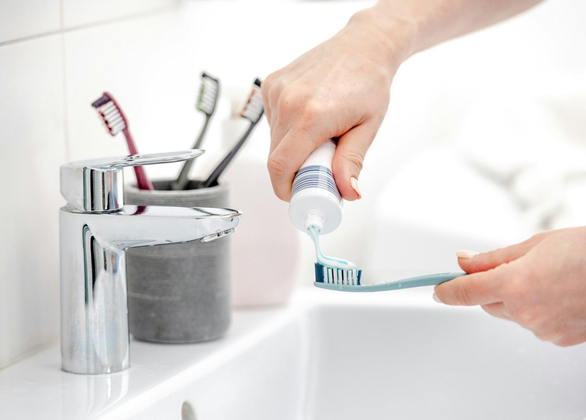 Girl'S Hand Applies Toothpaste To Brush
