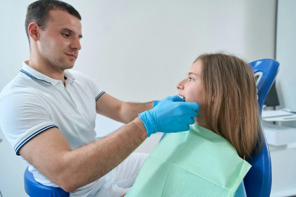 Pediatric dentist conducting orthodontic assessment of young patient