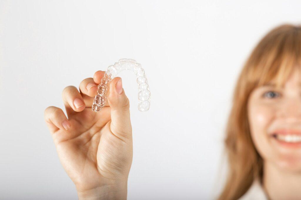 Beautiful smiling young woman with aligner.