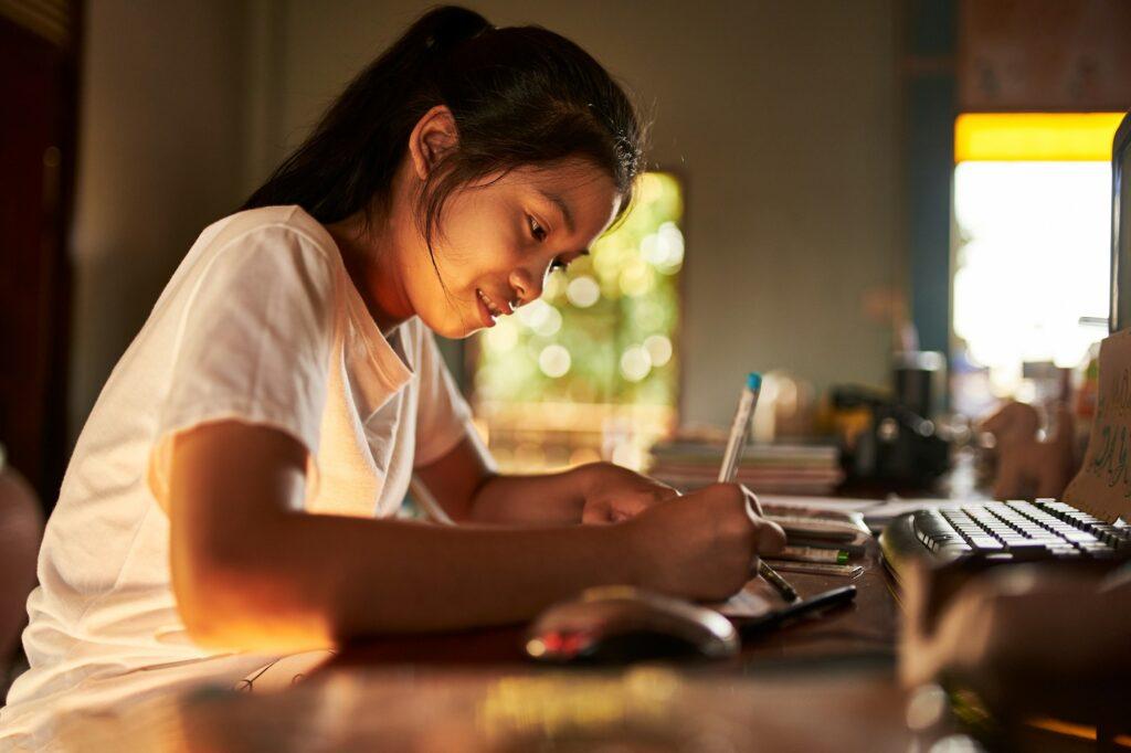 thai teen girl doing homework and studying at home