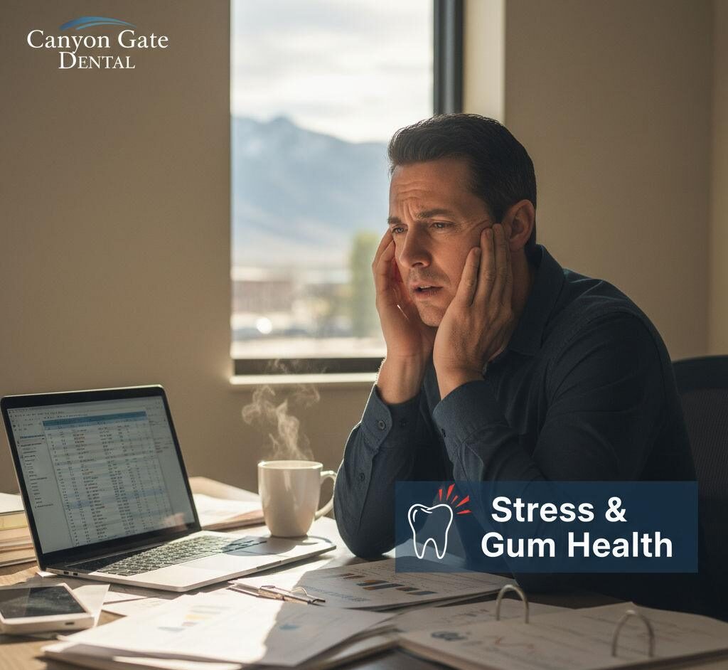 Stressed Orem resident touching their jaw while working on a laptop, symbolizing gum discomfort linked to stress.