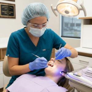 A Canyon Gate Dental dentist in Orem Utah placing a tooth-colored composite resin filling on a patient during a same-day restorative appointment