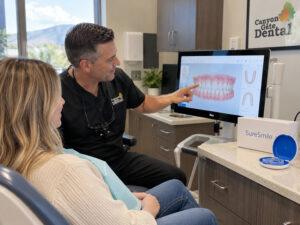 Adult patient reviewing a clear aligner treatment plan on a 3D scan with a dentist in Orem, Utah
